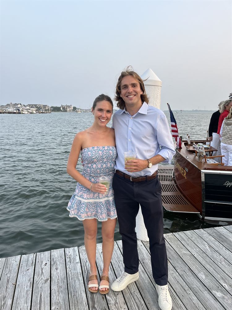 On a dock beside a wooden boat at dusk