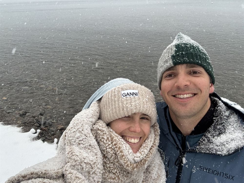 A selfie in falling snow beside a lake