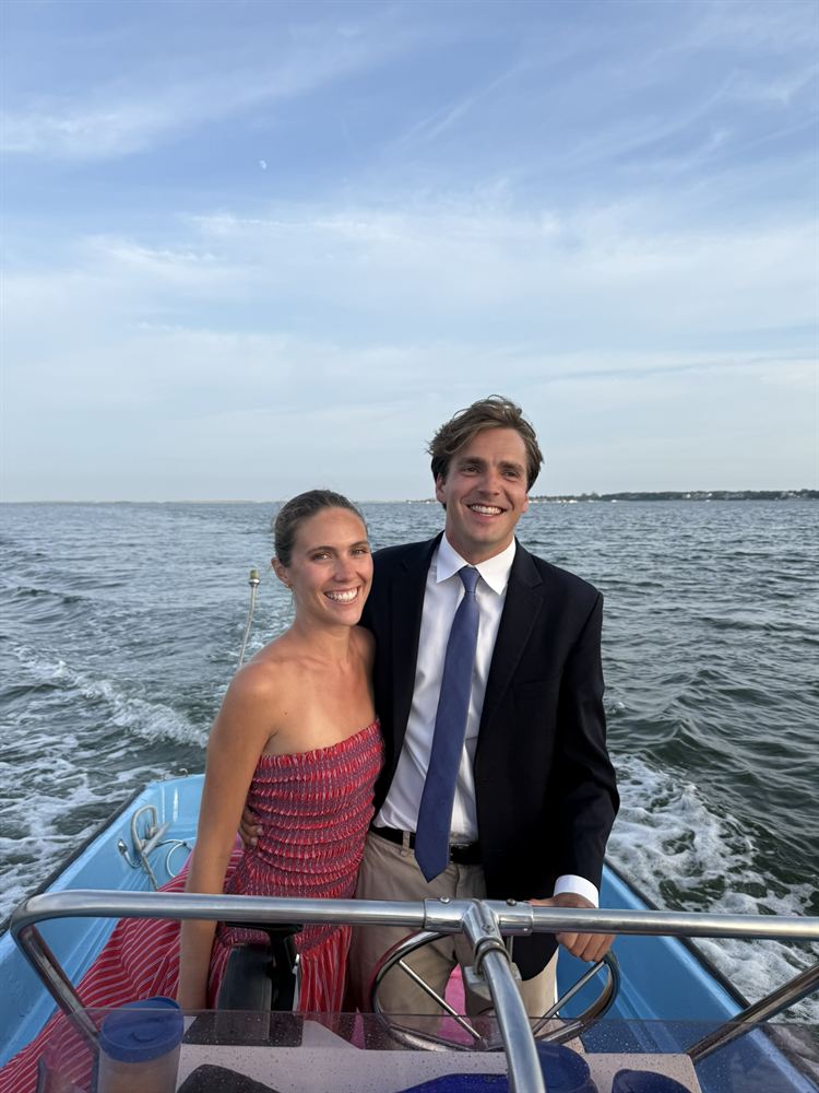 At the wheel of a small boat on the water