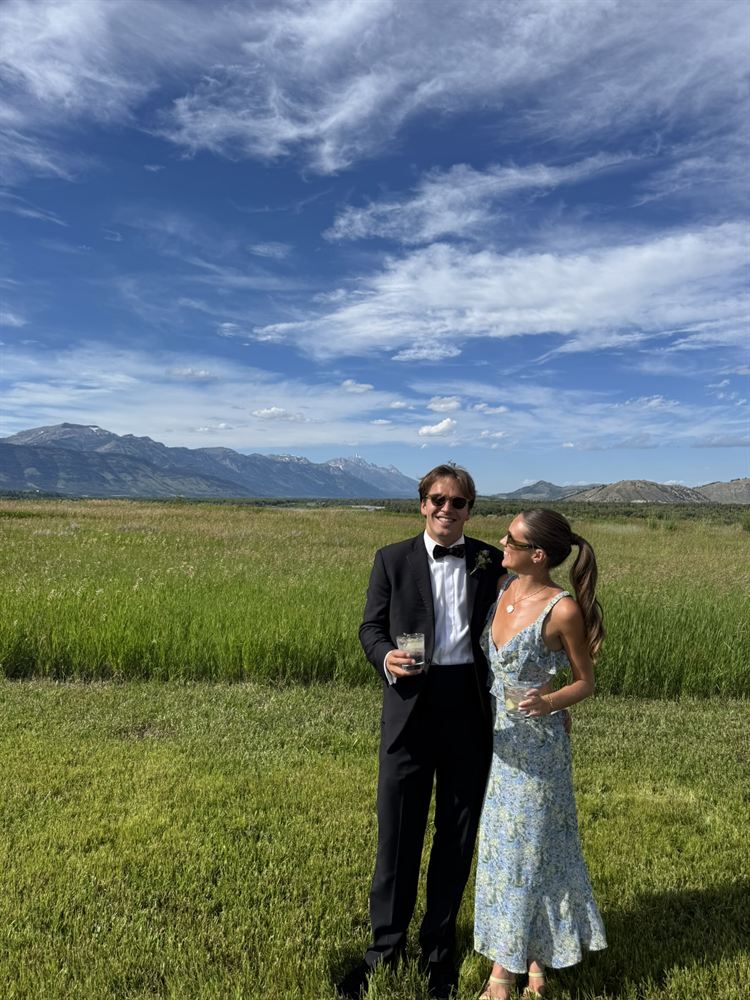 In a meadow with the Tetons behind them