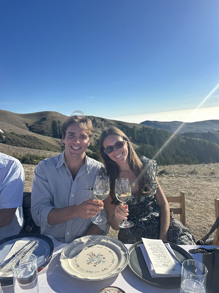 Raising wine glasses at a hilltop dinner