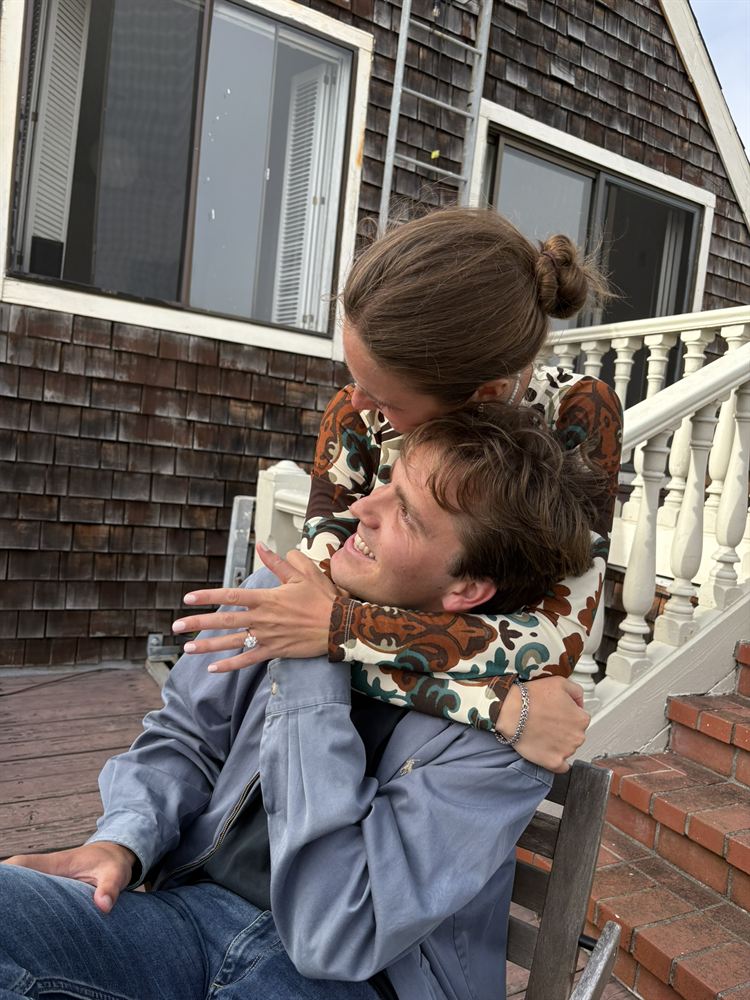 Cami hugging Blake from behind, showing her ring